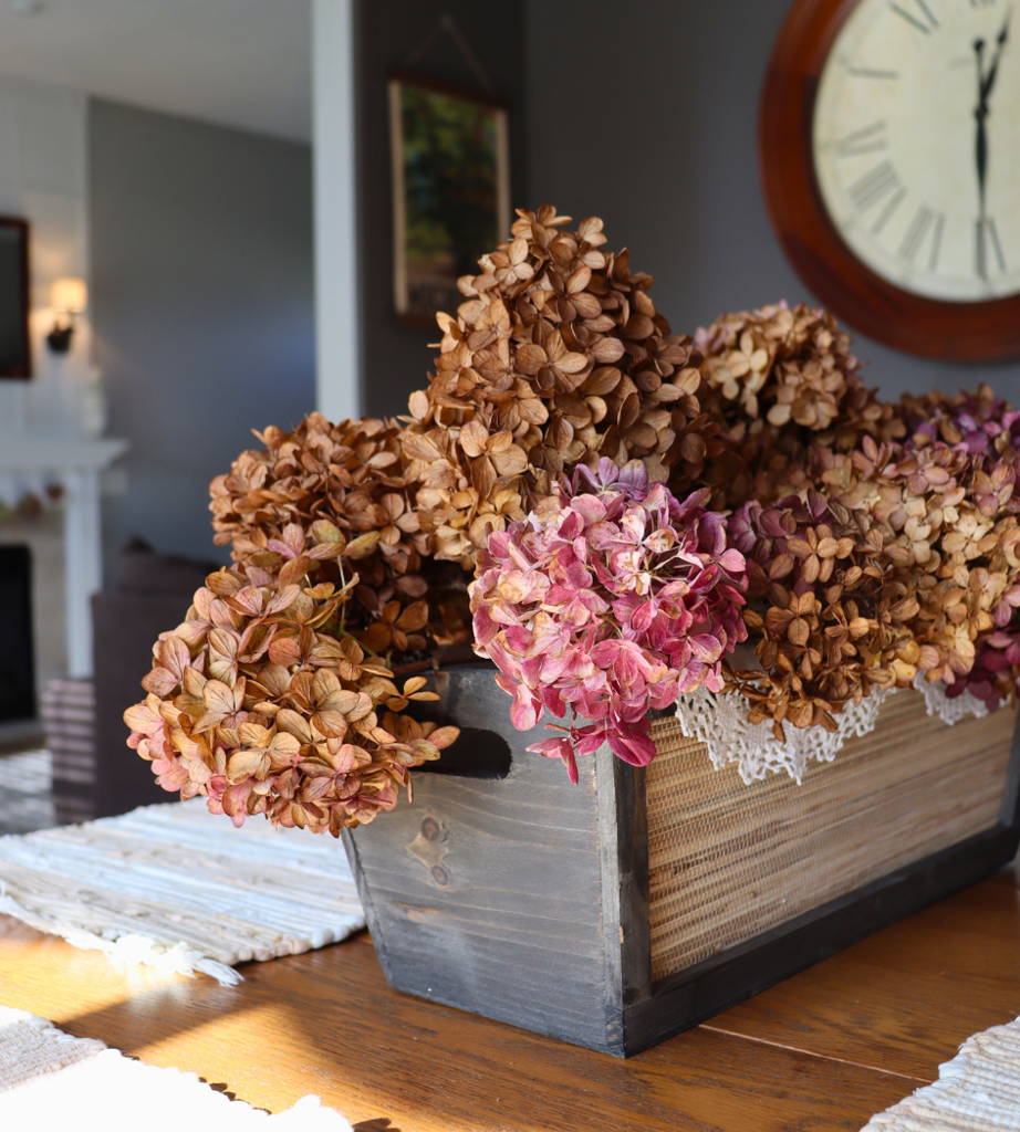 Pink and brown hydrangeas spilling out of a basket